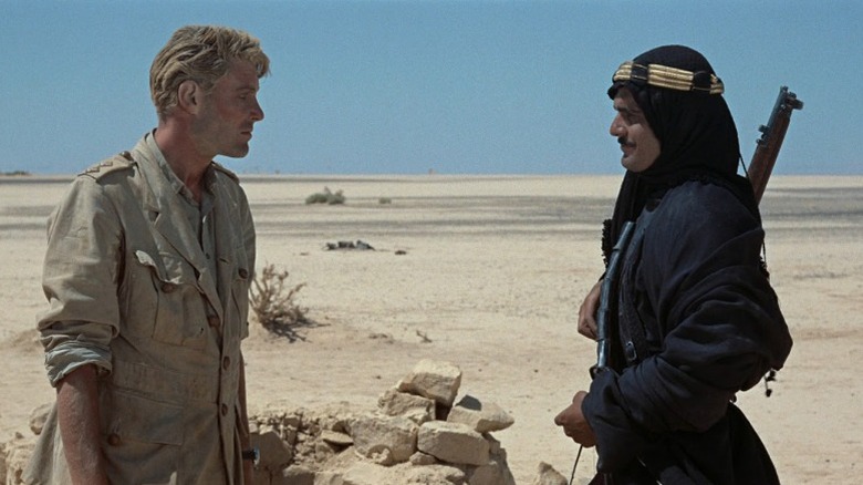 Peter O'Toole as T. E. Lawrence and Omar Sharif as Sherif Ali ibn el Kharish standing face-to-face in the desert in Lawrence of Arabia