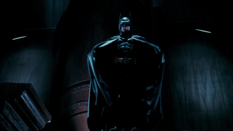 Michael Keaton's Batman is seen standing on a building ledge in Batman, about to extend his cape