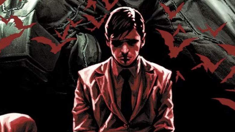 Bruce Wayne kneeling, bathed in red light