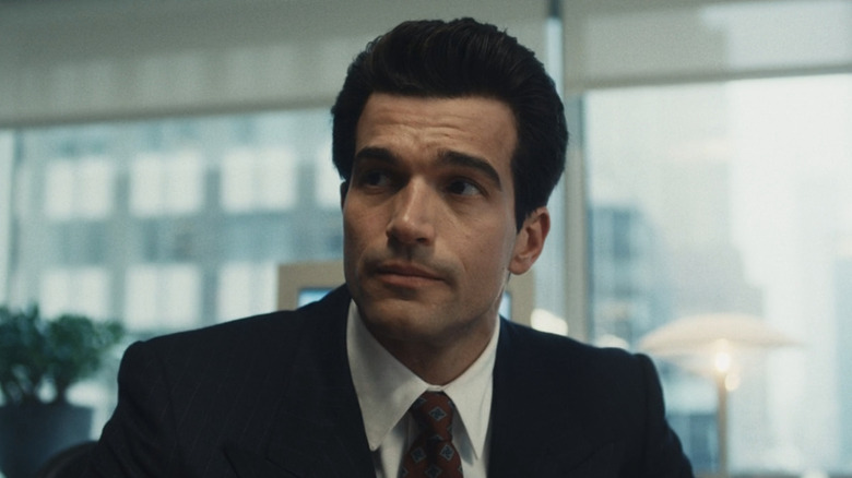 Paul Anthony Kelly as John F Kennedy Jr stands in an office in Love Story