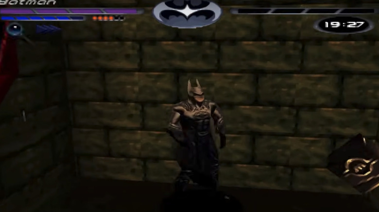 Batman stands against a brick wall in the Batman & Robin video game