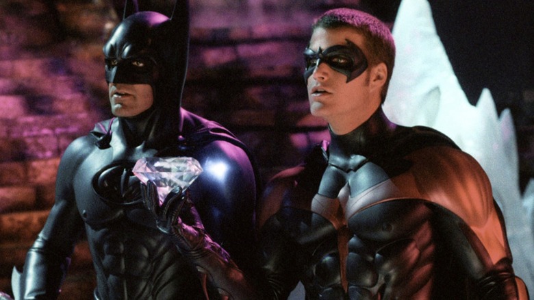Robin holds diamonds while Batman looks at Batman and Robin