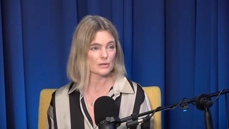 Erika Eleniak speaking into microphone on podcast