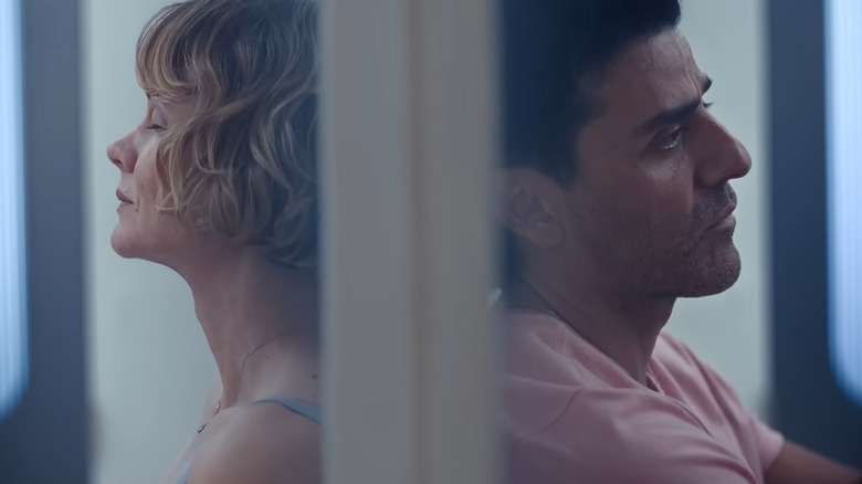 Oscar Isaac and Carey Mulligan in Beef sitting with back to each other, separated by a wall