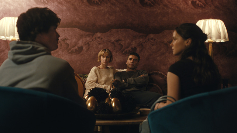 Oscar Isaac as Josh Martín and Carey Mulligan as Lindsay Crane-Martín sitting on a chair opposite Charles Melton as Austin Davis and Cailee Spaeny as Ashley Miller in Beef