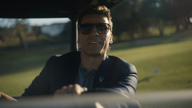 Oscar Isaac as Josh Martin driving a golf cart on a golf course in Beef season 2