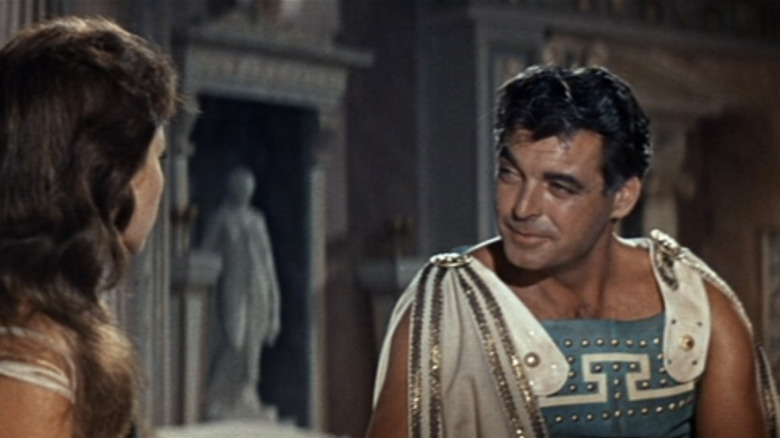 कोलोसस ऑफ रोड्स मधील राजवाड्यात बसलेले रॉरी कॅल्हॉनचे डॅरिओस ली मासारीच्या डायलाशी बोलत आहेत