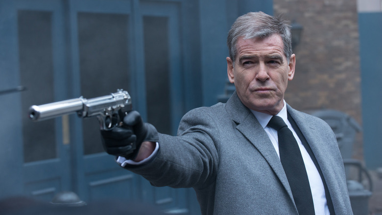 Pierce Brosnan as Nash holding a silenced pistol in Survivor (2015)