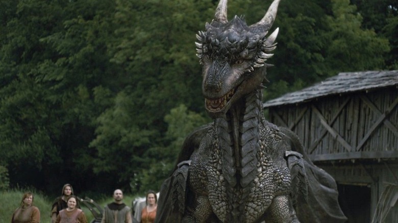 Draco the dragon standing next to a crowd of people in Dragonheart: Battle for the Heartfire