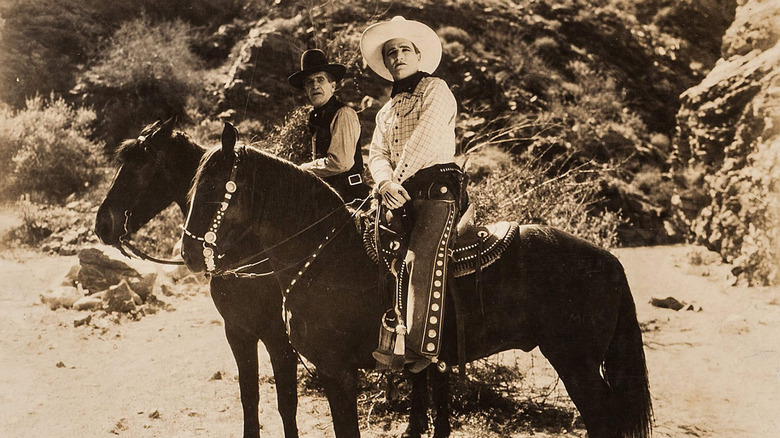 Tom Stone, on the back of Tony the Wonder Horse, riding next to Frank in a scene from the 1926 film No Man's Gold.