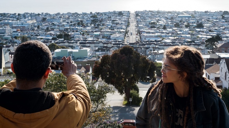 Karim taking a picture of a city with Fola looking on in The OA