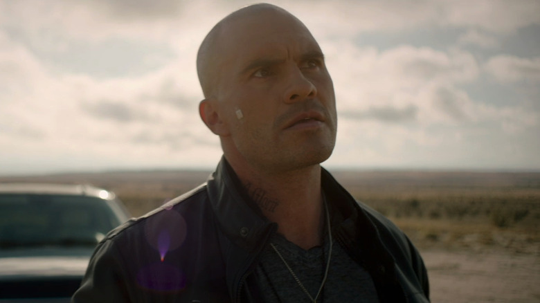 Juan Pablo Raba's Mauricio stands in front of his truck in the desert in The Marksman