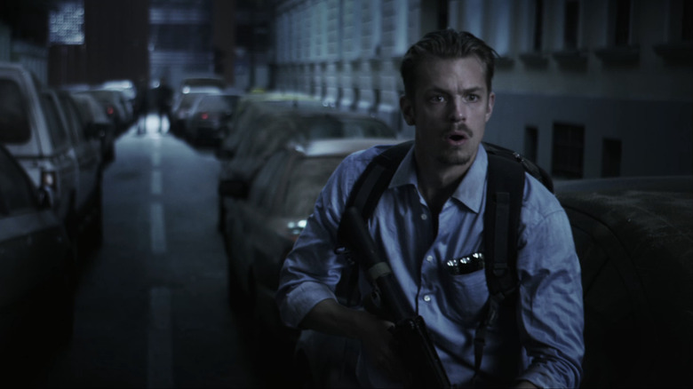 Joel Kinnaman's Skyler holds a rifle in the streets of Moscow in The Darkest Hour