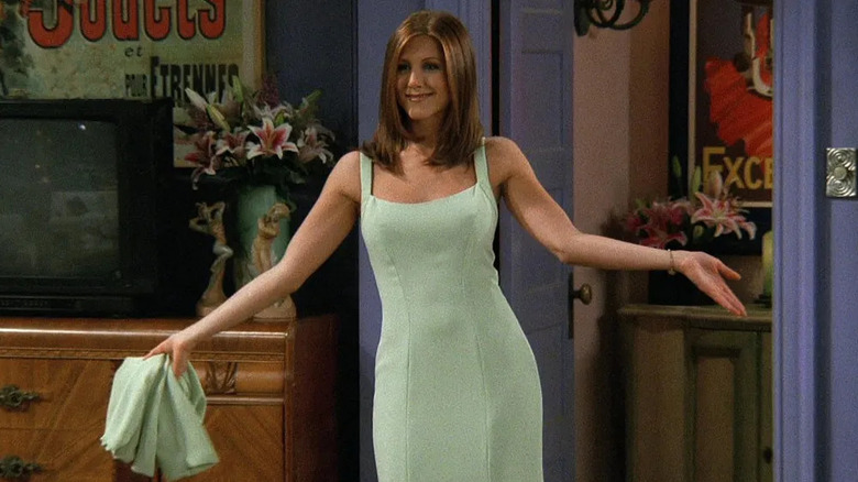 Rachel wearing a green dress and posing in the living room on Friends