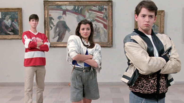 Cameron, Sloane, and Ferris standing in an art museum with their arms folded