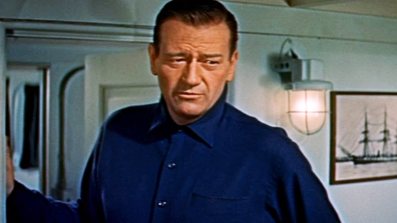 John Wayne's Captain Karl Ehrlich stands in a doorway in The Sea Chase