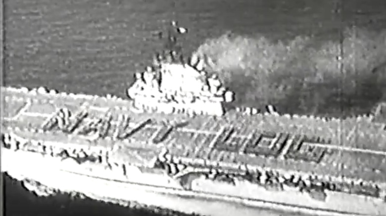 Naval officers form the words Navy Log on the deck of a ship in Navy Log