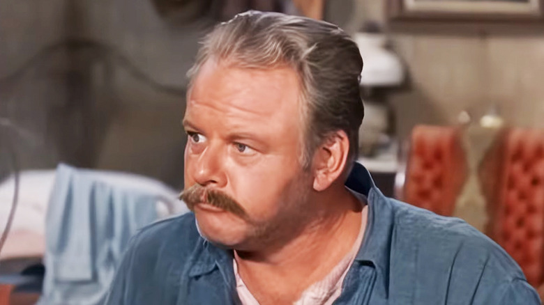 Alan Hale Jr's Swede Lundberg is seen looking to his right as he sits in a room in Bonanza