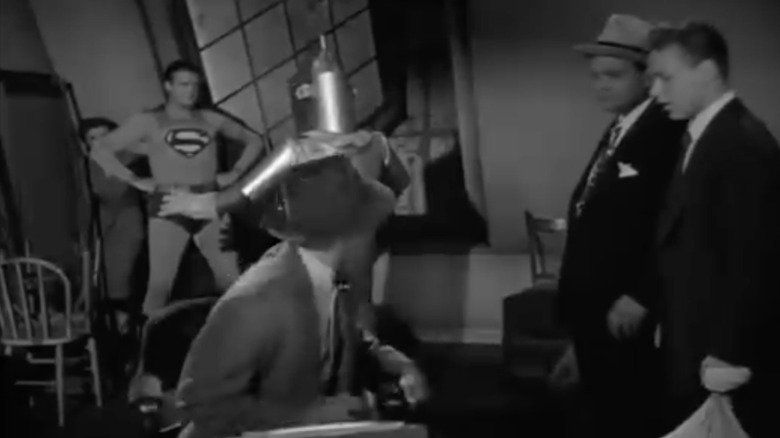 Russell Johnson's Chopper and his cronies look on as Superman battles a robot in Adventures of Superman