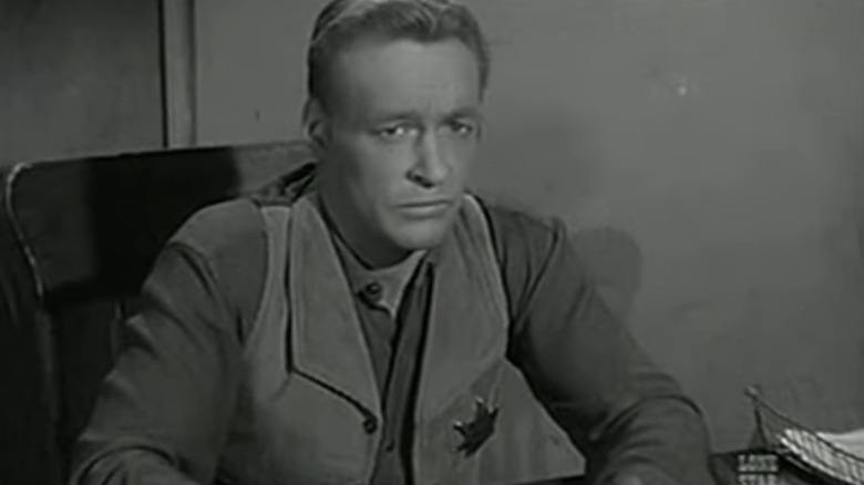 Russell Johnson's Marshal Gib Scott sits at his desk in Black Saddle