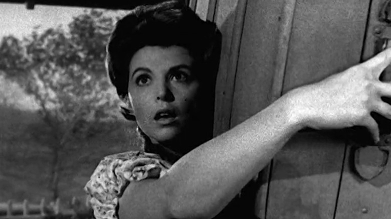 Tina Louise's Tilda Hicks looks shocked as she carries a suitcase on her shoulder in The Real McCoys