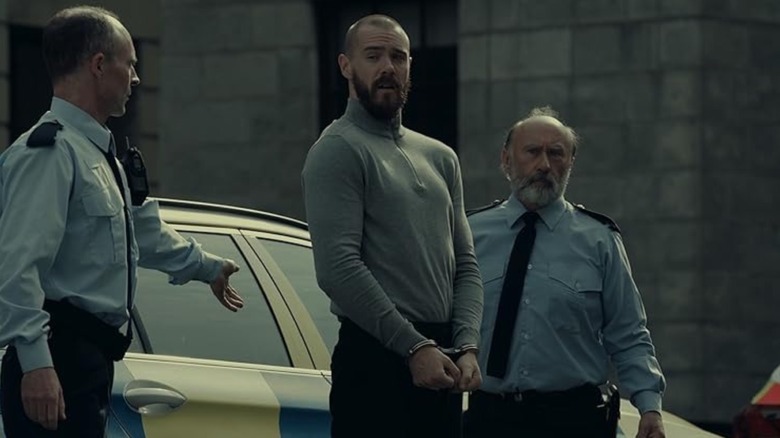 Sam Keeley as Eric 'Viking' Kinsella in Kin wearing handcuffs
