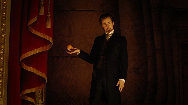 Edward Norton as Eisenheim holding an orange on-stage in The Illusionist