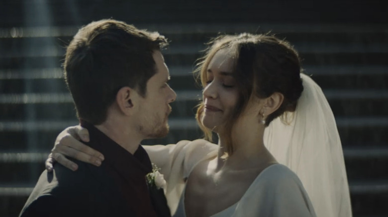Jack O'Connell's Jude Williams holds Olivia Cooke's Emma Ryerson on a set of stairs outdoors in Little Fish