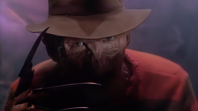 Robert Englund as Freddy Krueger raising his clawed hand in Freddy's Nightmares