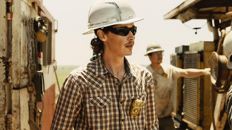 Jacob Lofland's Cooper Norris stands by an oil rig wearing a hardhat in Landman