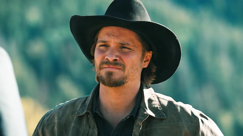 Luke Grimes' Kayce Dutton looks at someone standing off-screen as he stands outside in Marshals