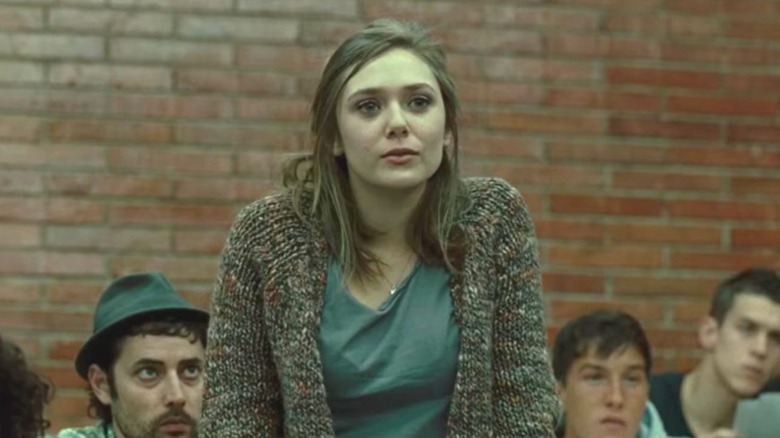 Elizabeth Olsen's Sally Owen standing up and wearing a cardigan in Red Lights