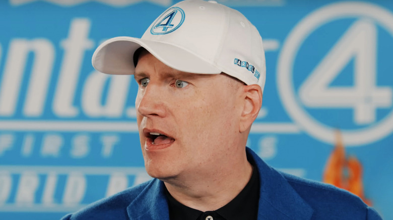 Kevin Feige looks shocked as he stands in front of a Fantastic Four sign