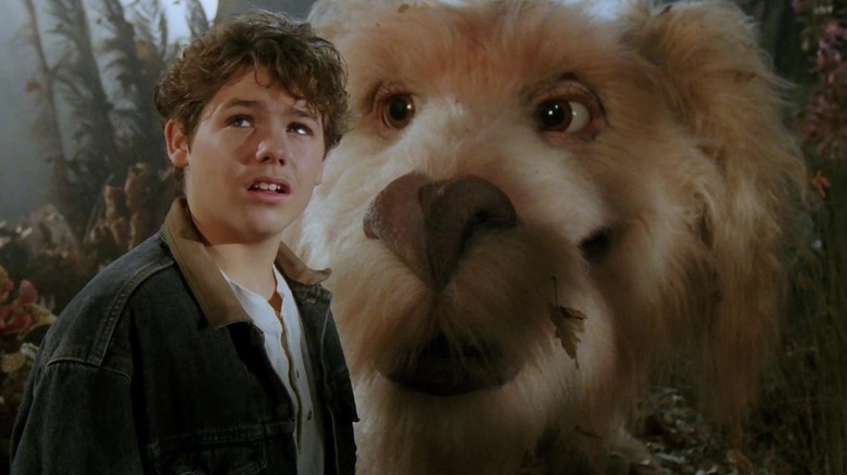 Sebastian standing next to the luck dragon Falcor in The NeverEnding Story III: Escape from Fantasia