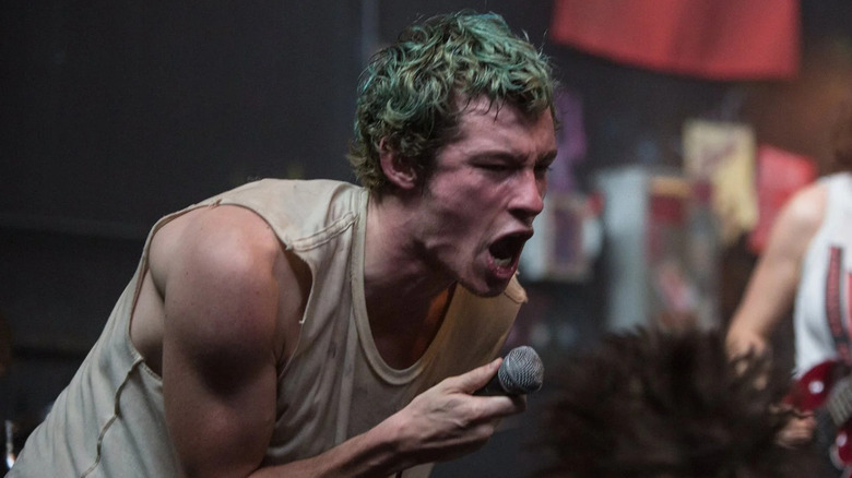 Callum Turner as Tiger yelling into a microphone in Green Room