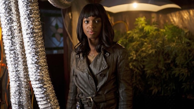 Enuka Okuma as Traci Naash in a coat standing by some plants in the Rookie Blue episode You Are Here