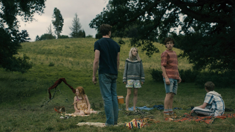 Tom Holland's Isaac, Saoirse Ronan's Daisy, George MacKay's Eddie, Harley Bird's Piper, and Danny McEvoy's Joe look worried in a field in How I Live Now