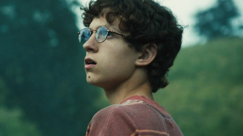 Tom Holland's Isaac stands in the country in How I Live Now