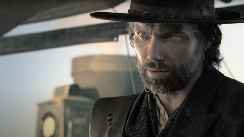 Anason Mount in the role of Colin Bouhanon wears dark clothes and looks angry at hell on wheels