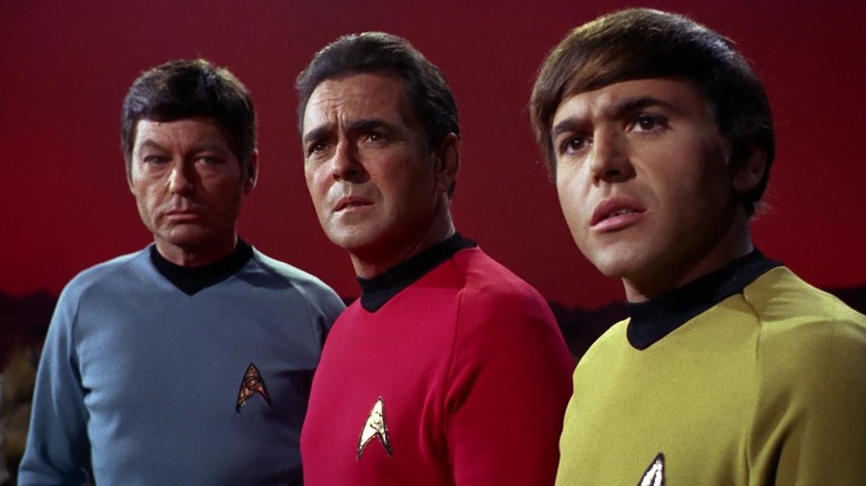 McCoy, Scotty, and Chekov standing side by side on Star Trek