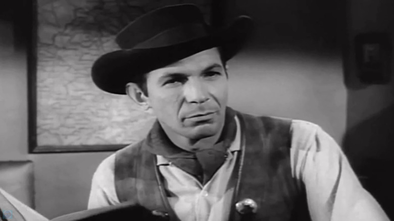 Leonard Nimoy's Del Hillman is seen in closeup sitting in an office in A Man Called Shenandoah