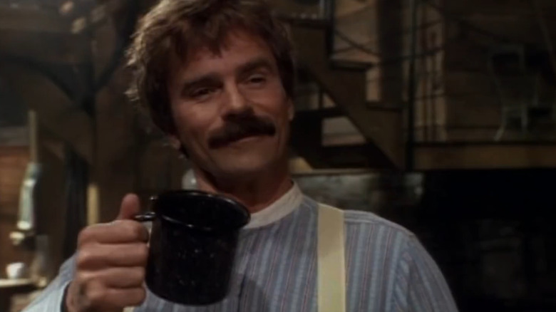 Ernest Pratt raising a camping mug on Legend