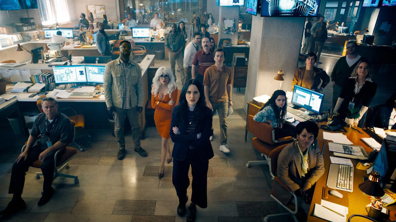 Lois Lane (Rachel Brosnahan) and the rest of the Daily Planet staff watch news on the television in "Superman"