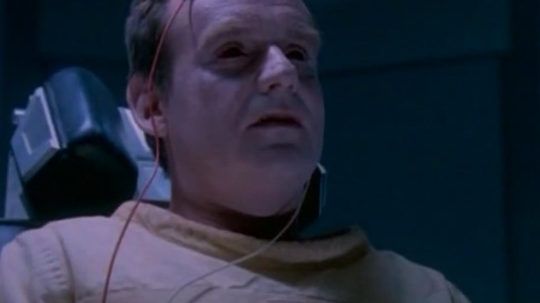 Paul Guilfoyle as Dr. Arthur Glyndon strapped to a chair in The Burning Zone