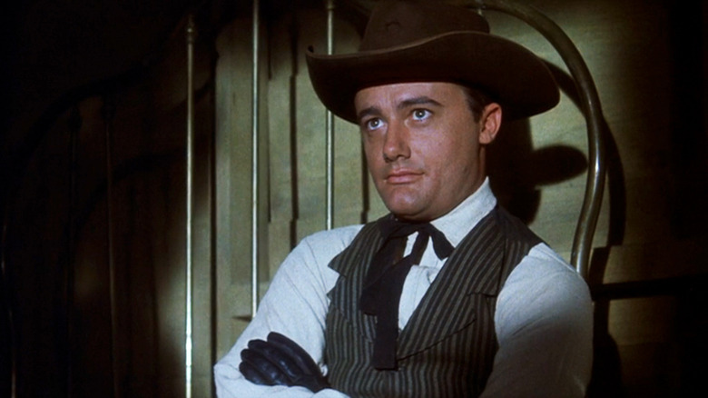 Robert Vaughn's Lee sits with his arms folded in The Magnificent Seven