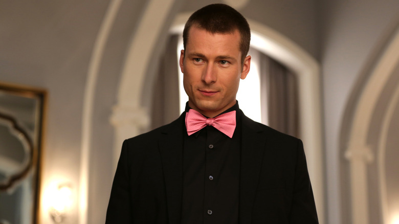 Glen Powell as Chad Radwell wearing a suit and bow tie in Scream Queens