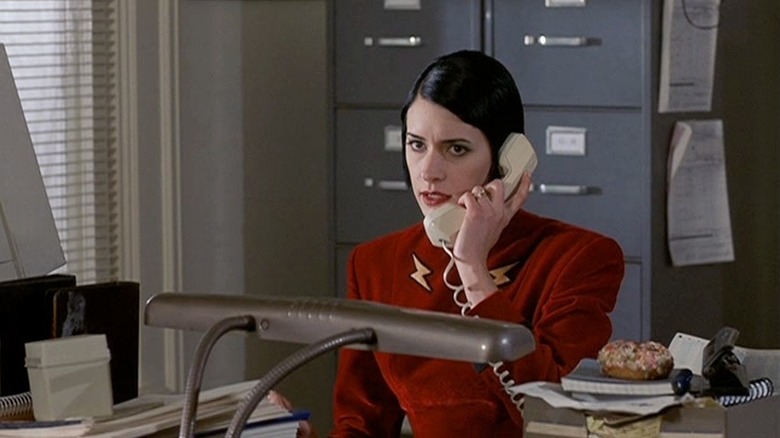 Ms. Indestructible on the phone in a boring office in The Specials.