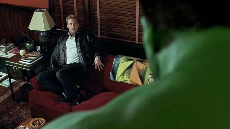 Josh Lucas's Glenn Talbot cowers on a couch as Eric Bana's Hulk looks down at him in Hulk