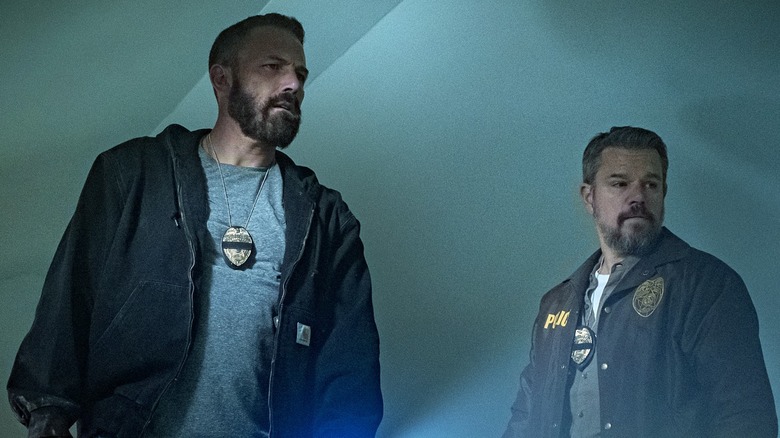 Ben Affleck as Det. Sergeant JD Byrne and Matt Damon as Lieutenant Dane Dumars standing in a hallway in The Rip
