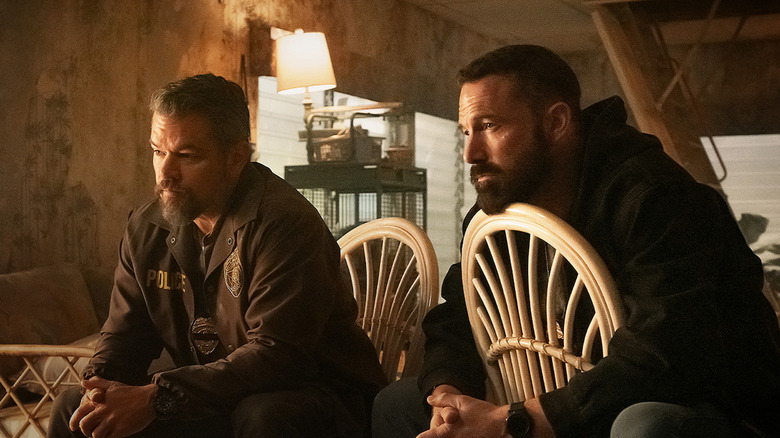 Matt Damon as Dane Dumars sitting in a chair next to Ben Affleck as JD Byrne in The Rip